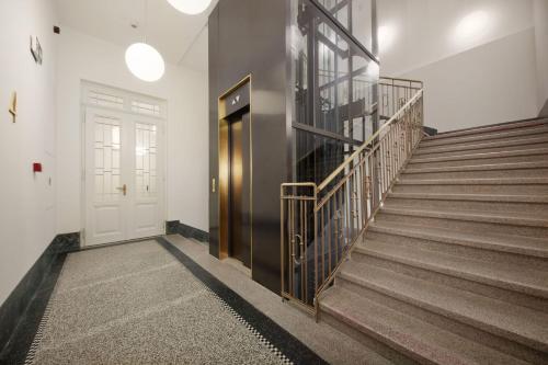 a hallway with a staircase with a door and a stair case at TurnKey I Premium Apartment in Prague