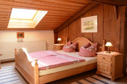 een slaapkamer met een bed in een kamer met houten wanden bij Beim Dokterer, Fewo ANNO DAZUMAL in Halblech