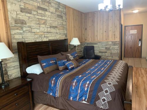 ein Schlafzimmer mit einem großen Bett und einer Steinmauer in der Unterkunft Corporate East Hotel in Ulysses
