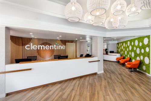 an office lobby with a reception desk and orange chairs at Clementine Hotel & Suites Anaheim in Anaheim