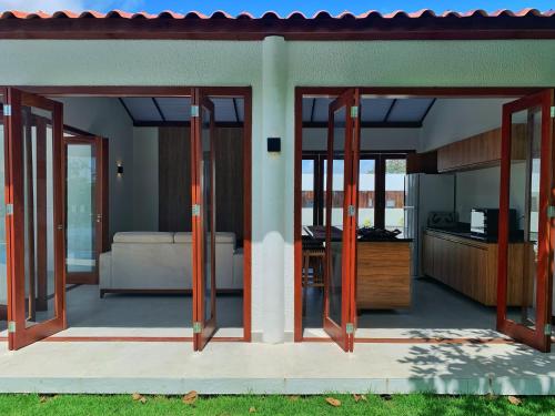 uma casa com portas que se abrem para uma sala de estar em Casa do Bem - Deluxe 3 bedroom villa with pool. em Pipa