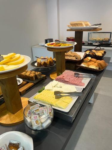 a table with many different types of food on it at Express Floripa Residence in Florianópolis