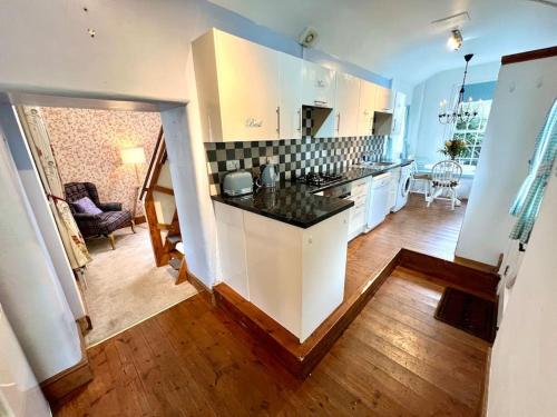 a kitchen with white cabinets and a counter top at Cosy 2 bed cottage on Dartmoor , Near Ivybridge in Plymouth