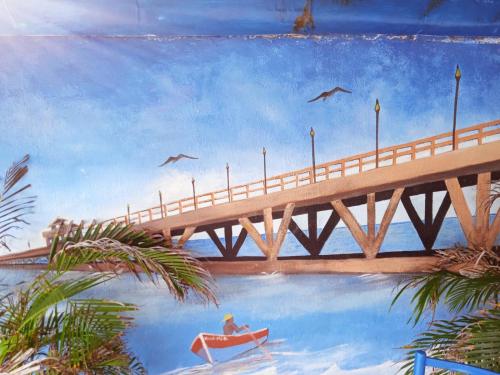 a painting of a bridge with a man in a boat at Villa mar in Puerto Colombia