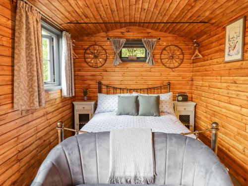 a bedroom with a bed in a log cabin at Hideaway Cabin in Exeter