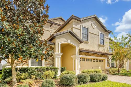 a house with bushes in front of it at Tropical Nights - 8 bed ChampionsGate Resort family pool home in Davenport