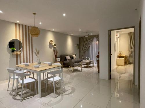 a dining room and living room with a table and chairs at Ipoh Waterpark Manhattan Premium Suites by IWH Suites in Ipoh