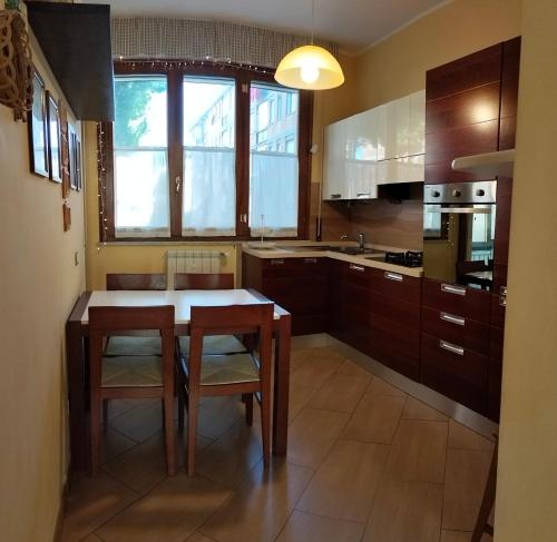 une cuisine avec une table et des chaises en bois ainsi qu'une cuisine avec un évier dans l'établissement Sunnyside Accademia, à Livourne
