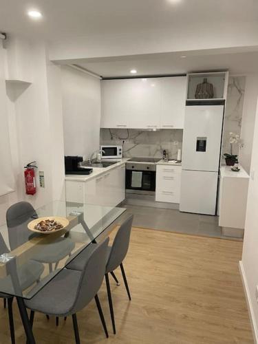 a kitchen with a glass table and chairs in it at Relax Sintra Home - Near Lisbon in Queluz