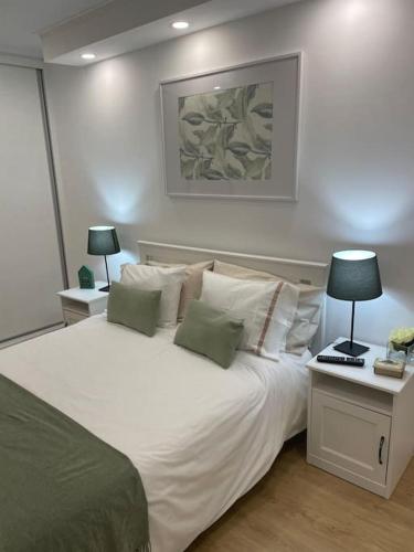 a bedroom with a large white bed with two lamps at Relax Sintra Home - Near Lisbon in Queluz