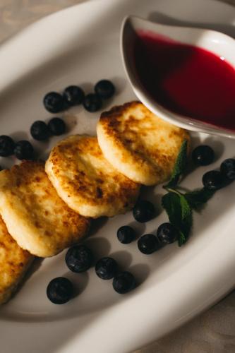 ein Teller mit Blaubeeren und einer Soße in der Unterkunft Belveder in Rohatyn