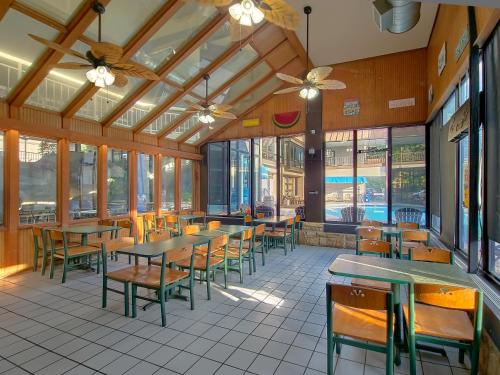 a restaurant with tables and chairs and windows at Sidney James Mountain Lodge in Gatlinburg