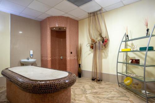 a bathroom with a tub and a toilet in a room at Хотел "Скалите", Skalite Hotel in Belogradchik