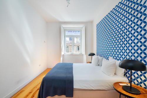 a bedroom with a bed and a blue and white wall at WHome Alecrim 43 Top Location perfect to explore Lisbon in Lisbon