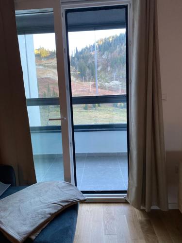 a bedroom with a sliding glass door to a window at MA Apartment Jahorina in Jahorina