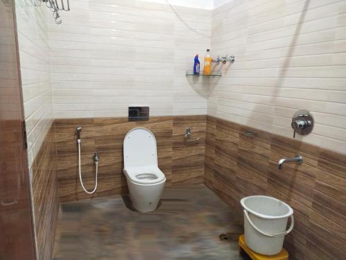 a small bathroom with a toilet and a bucket at Haveli Holiday Home in Mudigere