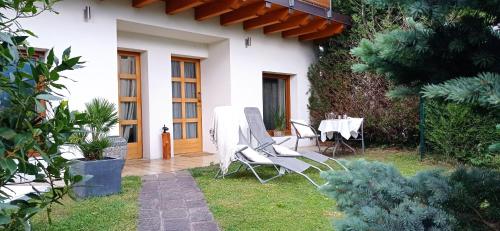 a house with a table and chairs in the yard at Villa Natura appartamento Open Space con giardino in Trento