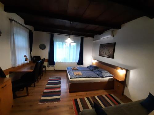 a bedroom with a bed and a desk and a table at Bodza Vendégház - Apartmanház in Demjén