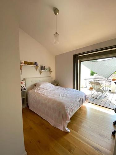 une chambre avec un lit et une grande fenêtre dans l'établissement Maison de ville entre amis ou en famille, à Castelnau-le-Lez