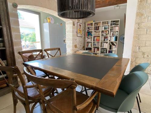uma sala de jantar com uma mesa de madeira e cadeiras em Maison de ville entre amis ou en famille em Castelnau-le-Lez