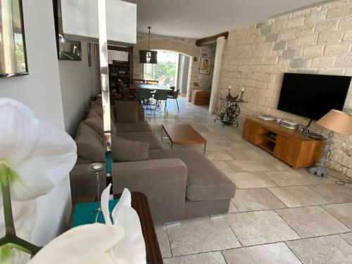 uma sala de estar com um sofá e uma televisão em Maison de ville entre amis ou en famille em Castelnau-le-Lez
