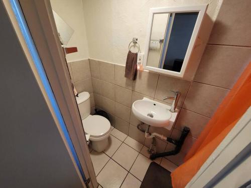 a small bathroom with a toilet and a sink at Comfortable Apartment - Pittsburgh's Little Italy in Pittsburgh