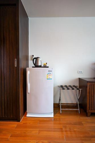 a kitchen with a white refrigerator in a room at Hotel Mermaid Bangkok in Bangkok