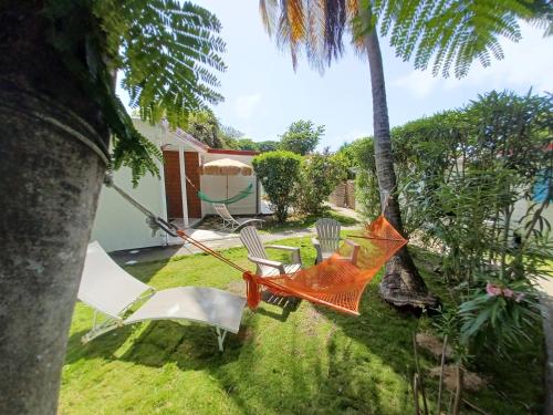 an orange hammock in the yard of a house at La Rose du Bresil Marie-Galante in Capesterre-de-Marie-Galante