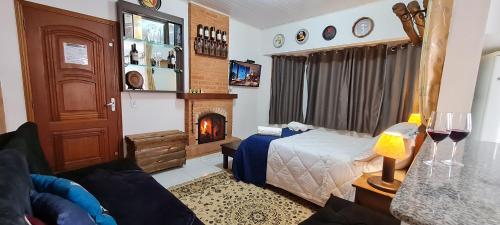 a living room with a bed and a fireplace at Do Sonho a Realizacao in Monte Verde