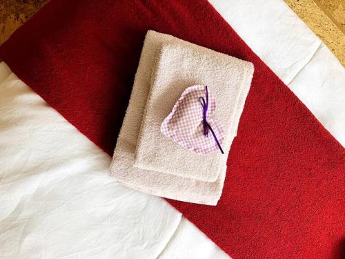 a napkin with a purple ribbon on a bed at Chesa Margadant in Zuoz