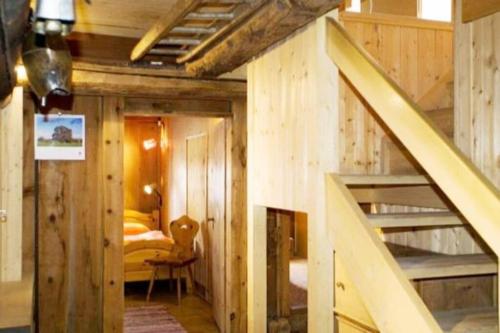 a room with a staircase and a bedroom with a bed at Chesa Margadant in Zuoz