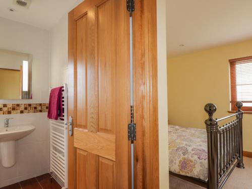 baño con lavabo y armario de madera en Lossiemouth Bay Cottage, en Lossiemouth