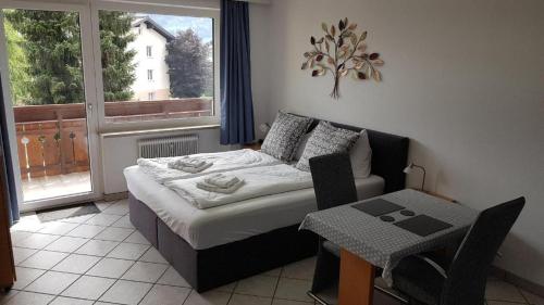 a bedroom with a bed and a table and a window at Studio-Apartment Areit in Zell am See