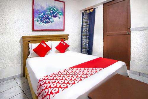 a bedroom with two beds with red pillows at OYO Hotel Brazil,Guadalajara,Estadio Jalisco in Guadalajara