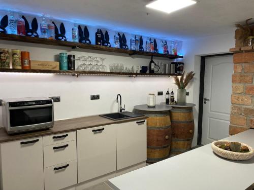 a kitchen with white cabinets and a sink and a microwave at Palavahof in Perná
