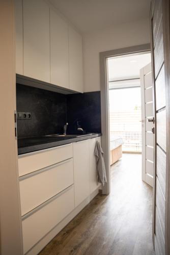 a kitchen with white cabinets and a sink at Palavahof in Perná