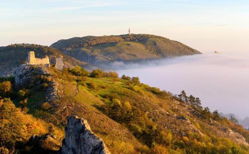 a castle on top of a hill above a fog covered mountain at Palavahof in Perná