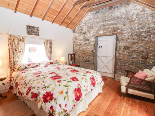 a bedroom with a bed and a stone wall at The Dairy in Clonmel