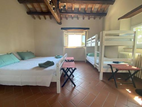 1 dormitorio con 1 cama y 1 litera en Villa Ginevri, La casa vacanze immersa nel verde, en Mondavio
