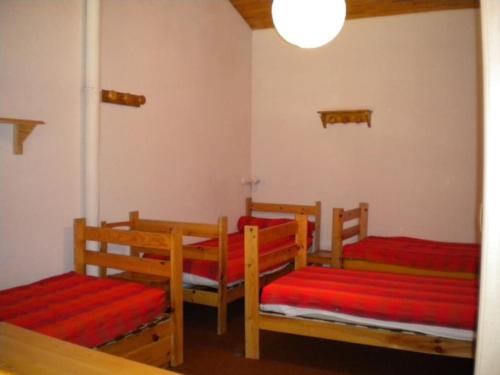 a room with three wooden chairs with red cushions at Appt Plagne Village skis aux pieds - LES HAMEAUX 2 in Plagne Villages