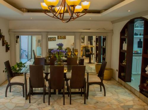 a dining room with a table and chairs and a chandelier at Villa 97 guayaquil Suites y Habitaciones Económicas Cerca del Aeropuerto in Guayaquil