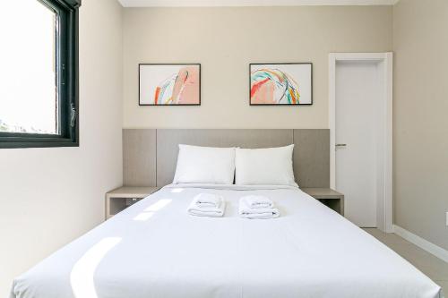 1 dormitorio con 1 cama blanca grande y 2 toallas en WI-FI 300MB | 400m da UFSC #CARV01, en Florianópolis