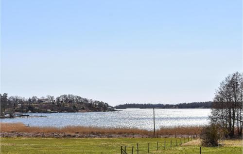 a body of water with a fence and a field at 3 Bedroom Beautiful Home In Ronneby in Ronneby