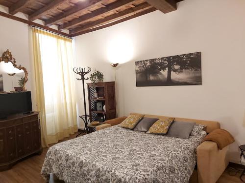 a bedroom with a bed and a television in it at Vicolo Antico Apartment in Rome