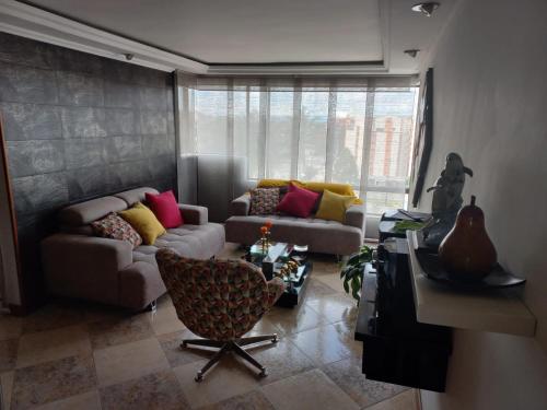 a living room with two couches and a table at APARTA-HOTEL BADEN in Bogotá