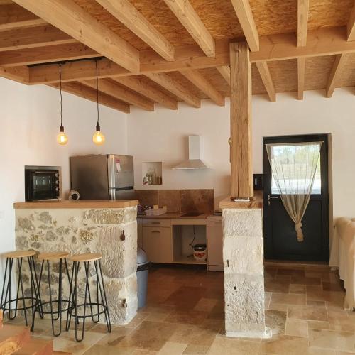 une cuisine avec un comptoir, une table et des chaises dans l'établissement Cottage chaleureux dans un Domaine d'exception, à Nomdieu