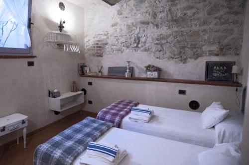 una camera con due letti in una stanza con un muro di pietra di Chianti-Home Palagione a Strada