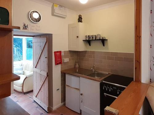 a kitchen with a sink and a stove at The Snug in Aberaeron