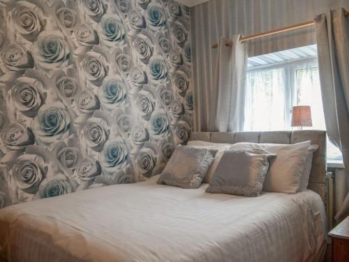 a bedroom with a wall covered in blue roses at The Snug in Aberaeron