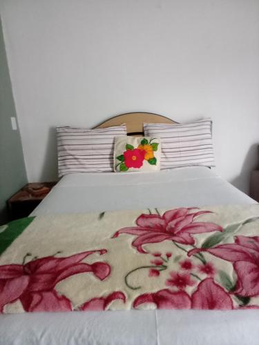 a bed with a flower arrangement on top of it at Minha casa pousada in Botucatu